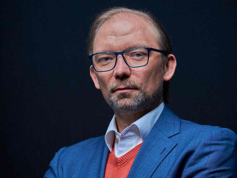 C-Level Portrait ab 2.500 Euro: Geschäftsführer im blauen Anzug vor dunklem Hintergrund