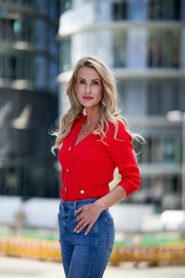 Melanie Kleemann, Executive-Beraterin, im roten Pullover vor einer Glasfassade