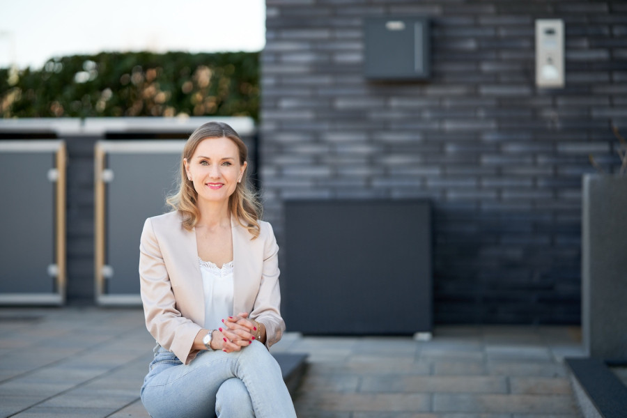 Frau im Business sitzt auf Bank