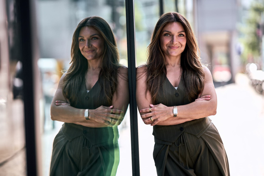 Businessfrau an einer Glasfassade angelehnt, Personal Branding in NRW