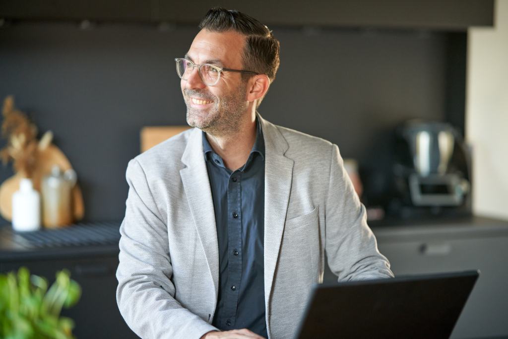 Matthias Skaletz, Businessfotograf, im grauen Blazer am Laptop